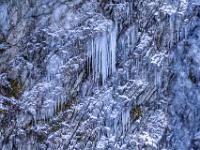 Verschieden große Eiszapfen hängen an den Felsvorsprüngen